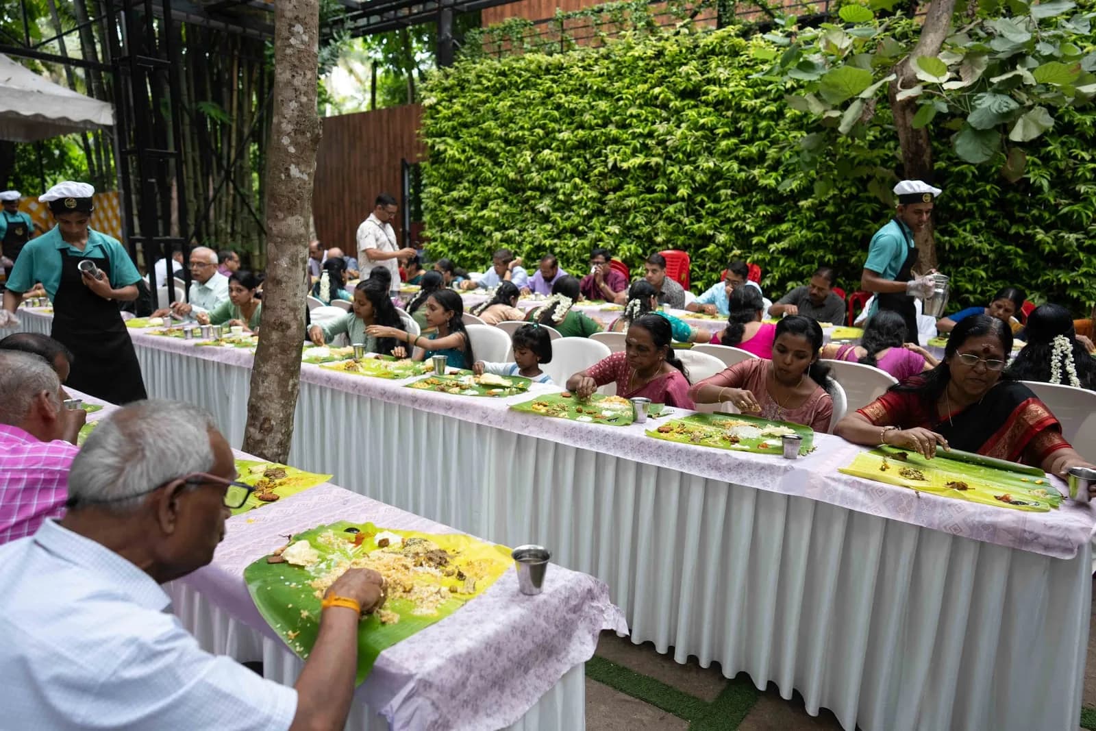 Guests enjoying a garden sadhya